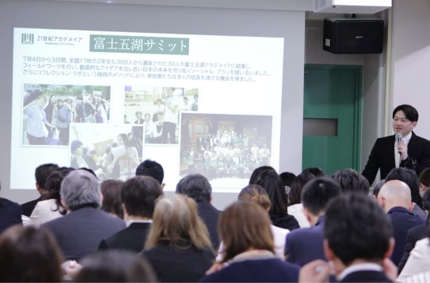 大きなスクリーンで説明を聞く保護者説明会の様子