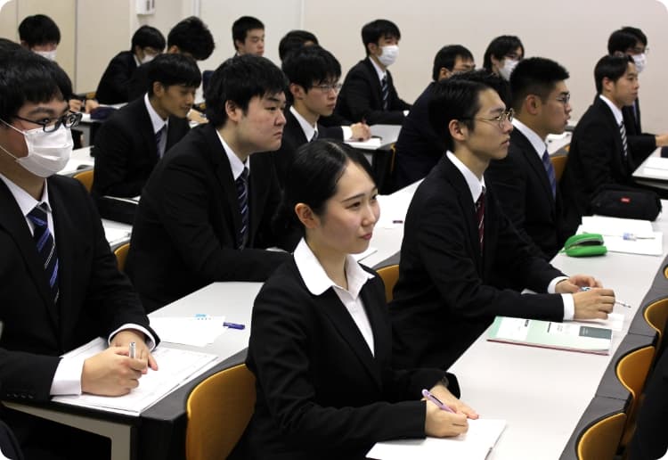 学生たちが教室で並んで講義を受けている様子